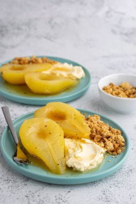 two plates of poached pears with forks close up