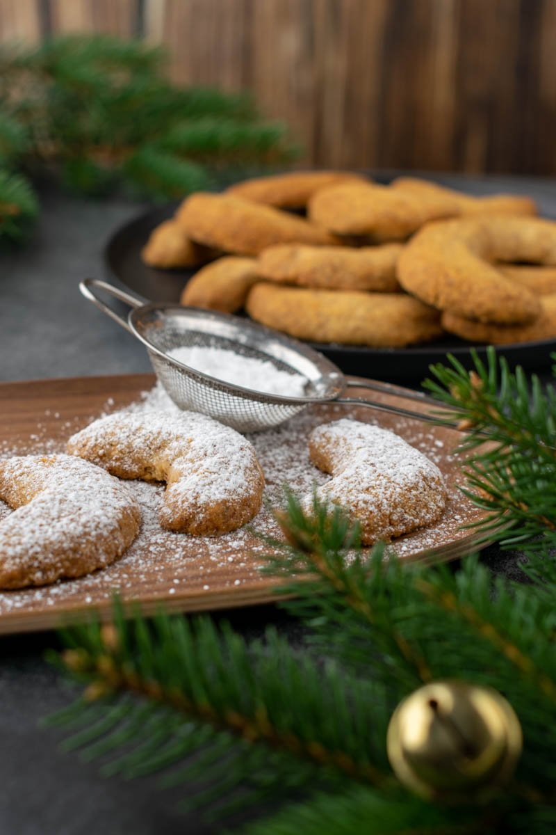 Almond crescent cookies on a wooden plate. Close view. 